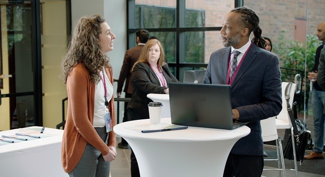 Speaker at a conference being approached by a woman