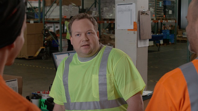 Male warehouse worker being bullied by male coworkers