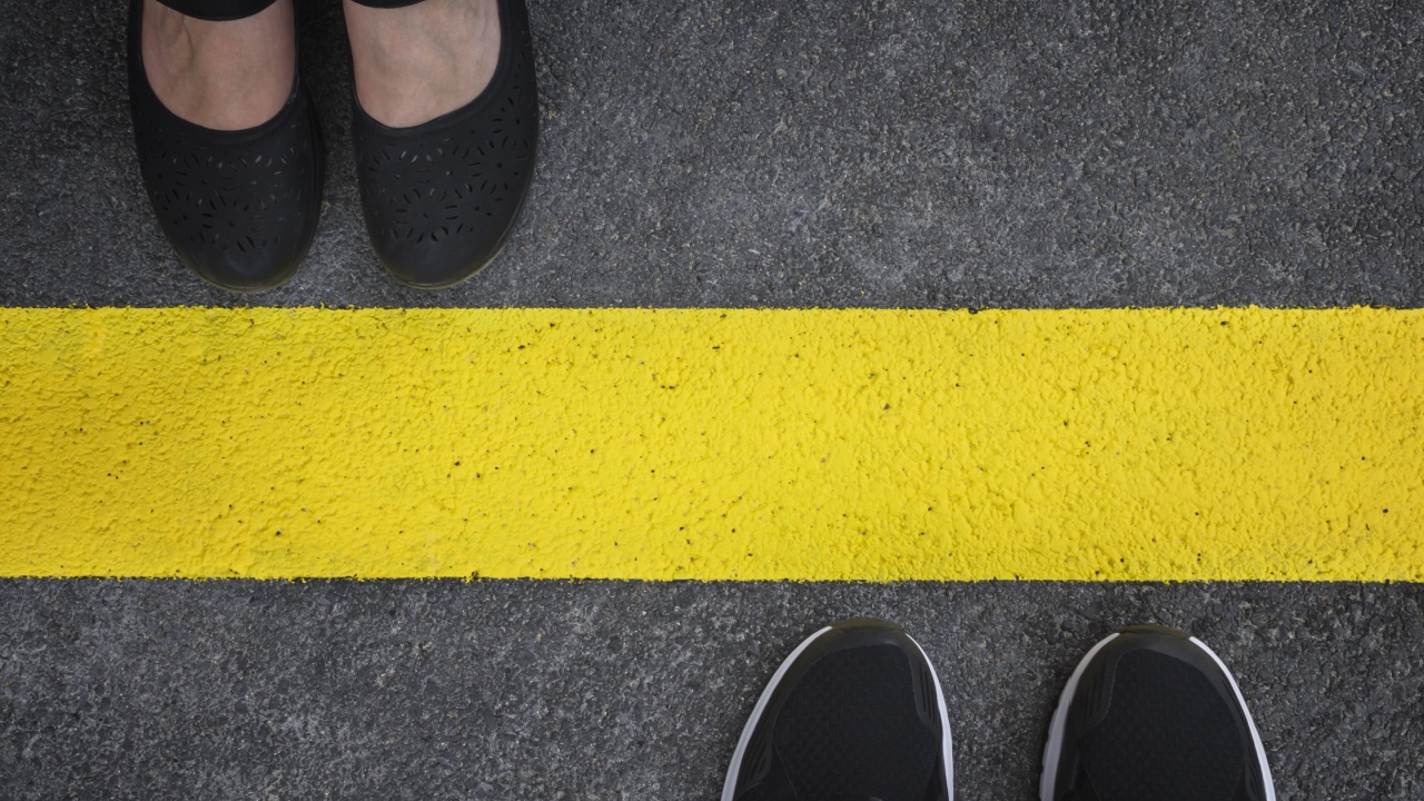 People honoring a boundary by not crossing the painted line