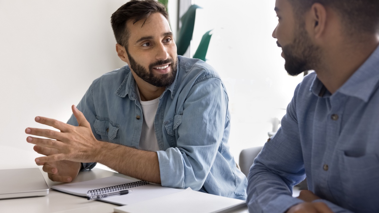 Male manager having positive coaching session with employee