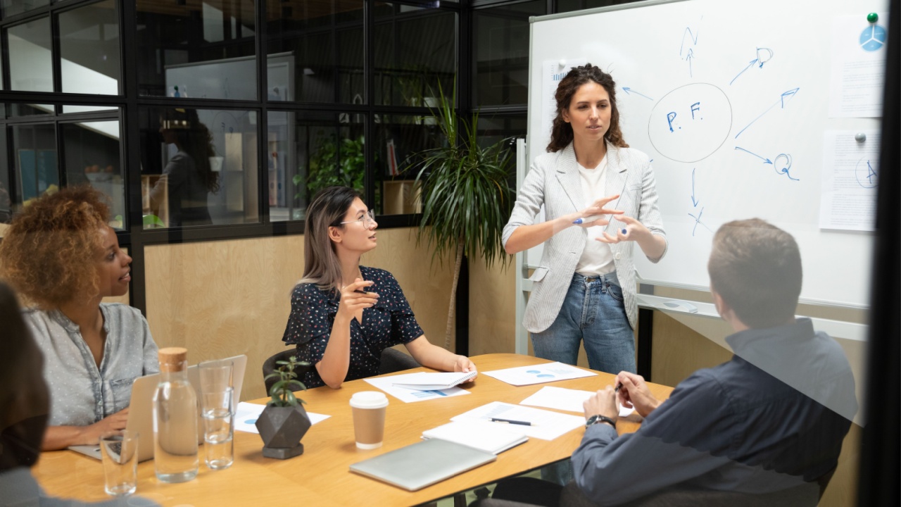 Female leader making a presentation to colleagues sitting around a table